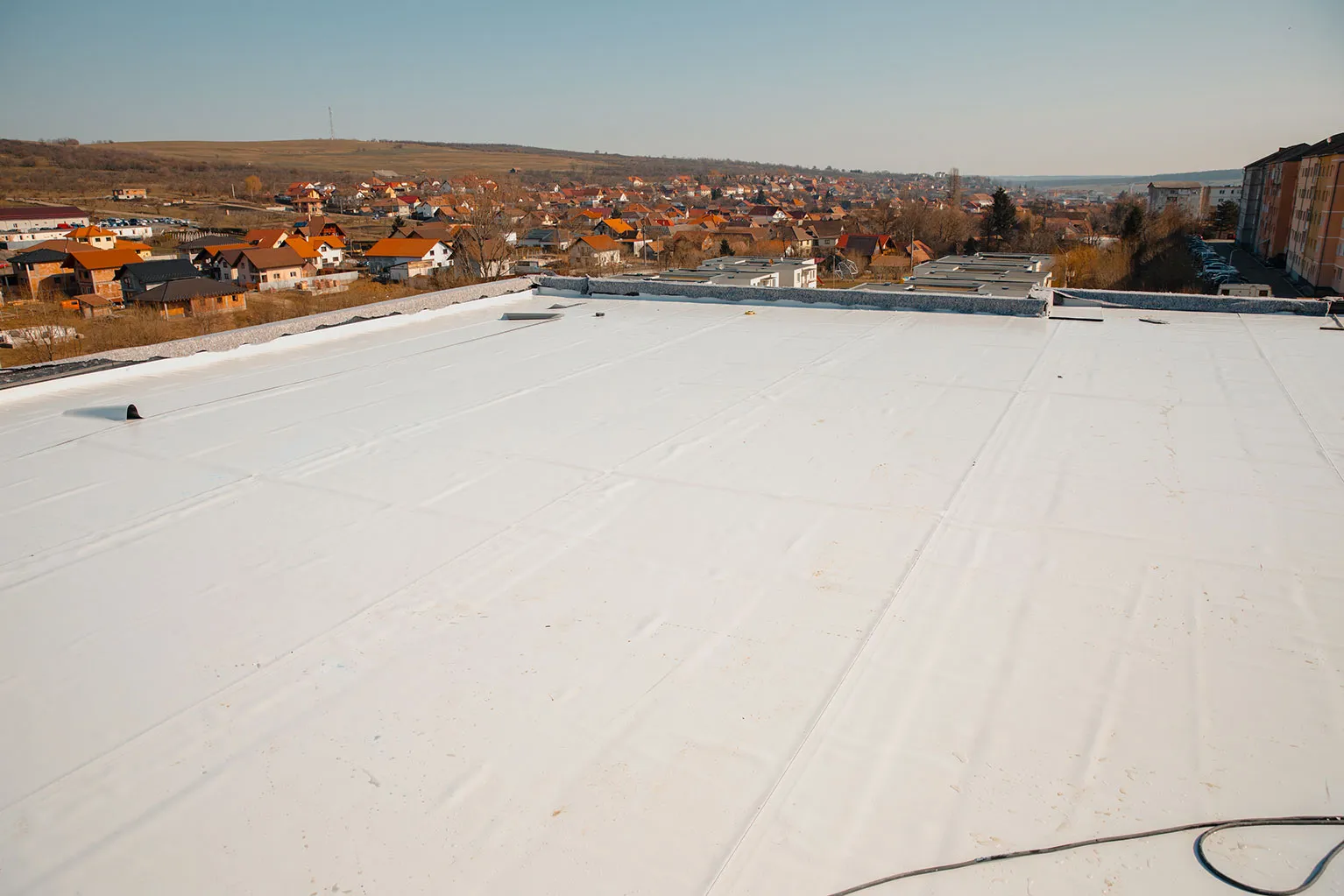 A flat roof with a white tarp on top of it.
