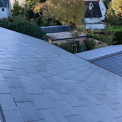 A cat sitting on the roof of a house.