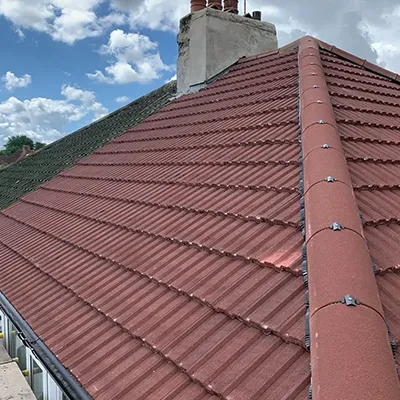 A cat sitting on top of a roof next to a building.