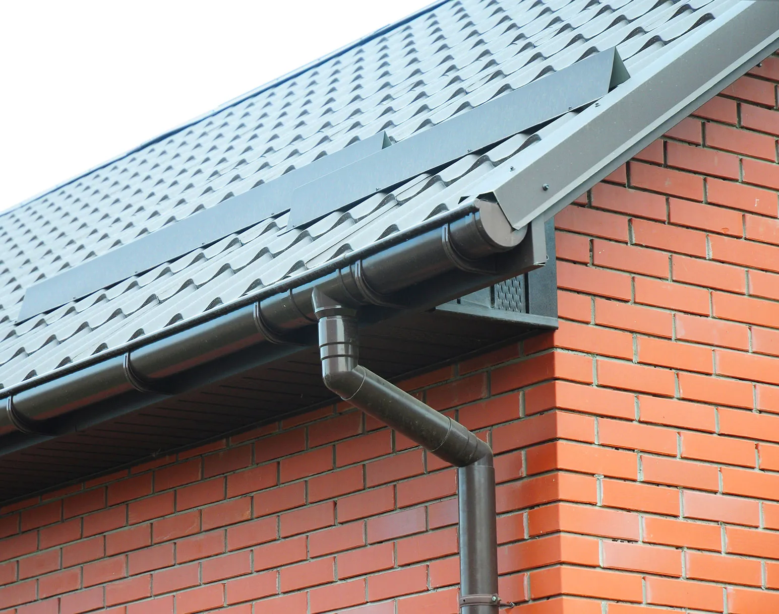 A metal gutter attached to a brick building.