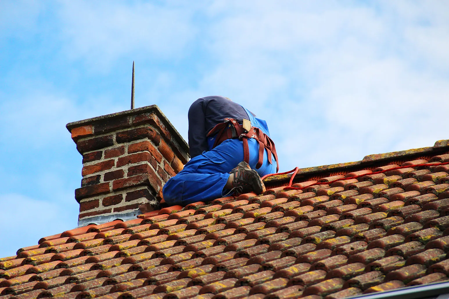 A man working on the roof of a house.